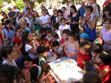 Los chicos alrededor de la torta Cantando el feliz cumpleaños a su Jardin.